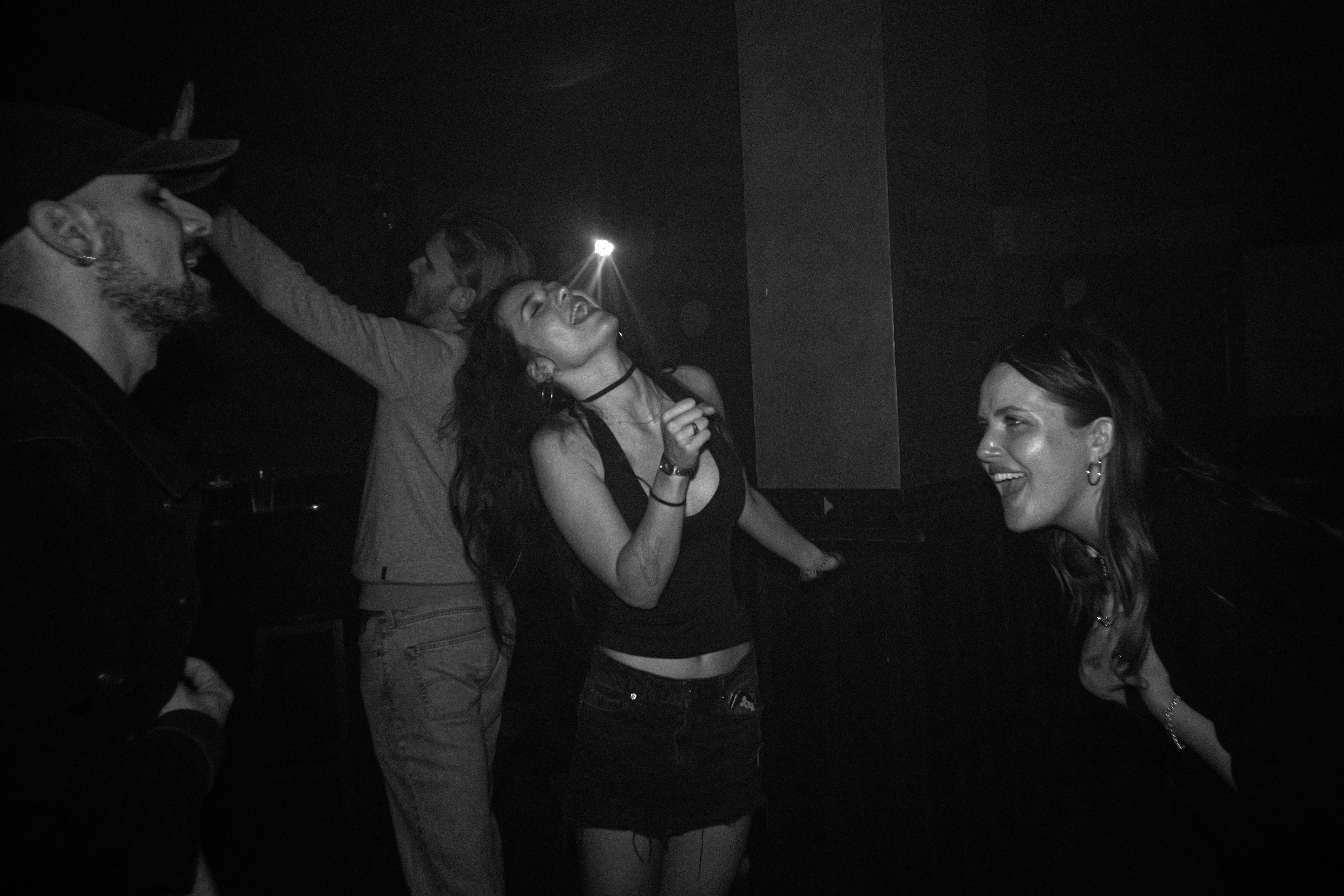 Schwarzweiss-Foto von Menschen, die in einem Nachtclub tanzen und Spaß haben.